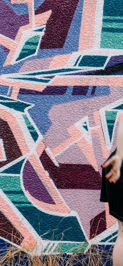 SPHERE marks 10 years of Australian Dance Party A figure is paused mid-motion on the right. The wall to her left is a mural of angular shapes