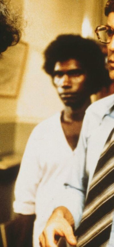 Two Aboriginal men standing next to two white men in an office