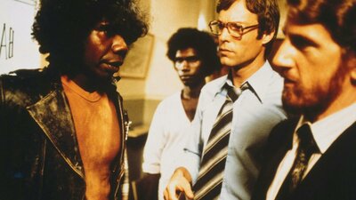 Two Aboriginal men standing next to two white men in an office
