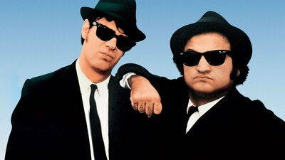 Promotional image from The Blues Brothers showing two men in dark suits and sunglasses