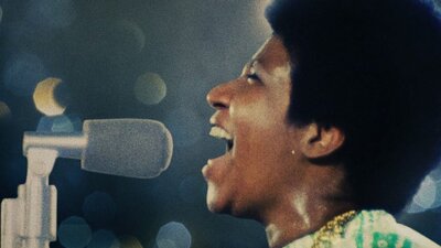 Still from Amazing Grace showing a woman singing into a microphone