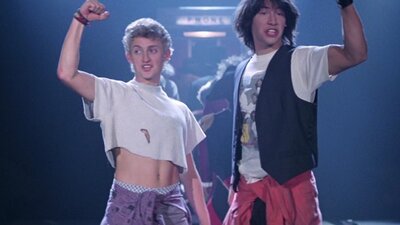 Still from Bill & Ted's Excellent Adventure showing two teenagers raising their fists