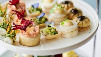 Close up of plated of small high tea items such as cakes and tarts