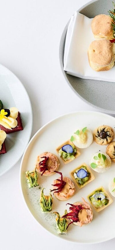 Birds eye view of three high tea plates featuing scones, cakes and small goods