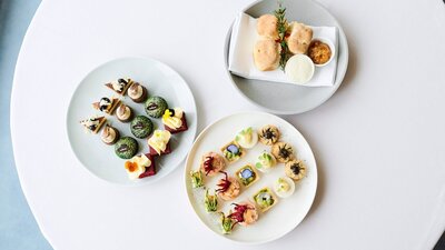 Birds eye view of three high tea plates featuing scones, cakes and small goods