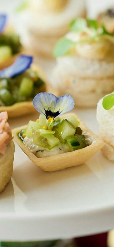 Close up of plated of small high tea items such as cakes and tarts