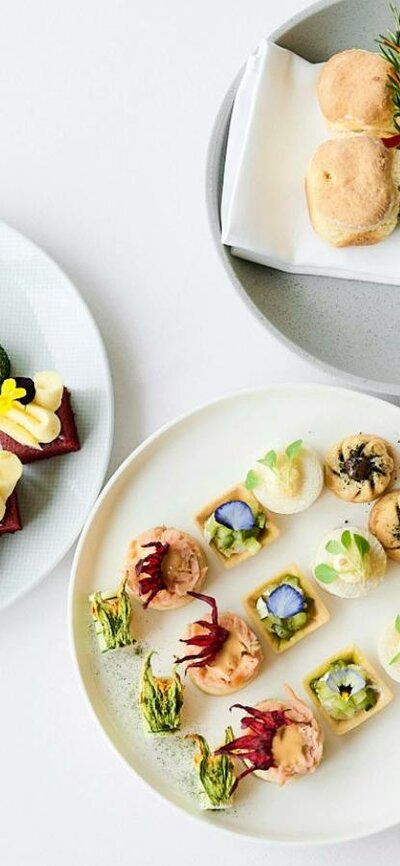 Birds eye view of three high tea plates featuing scones, cakes and small goods