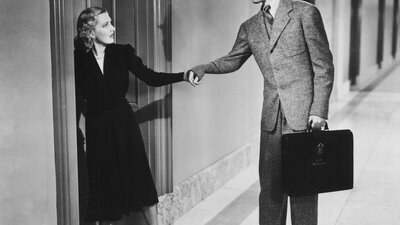 Black and white still of woman pulling a mans wrist to follow her