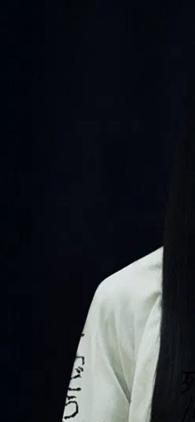 Faceless figure with long black hair and black background