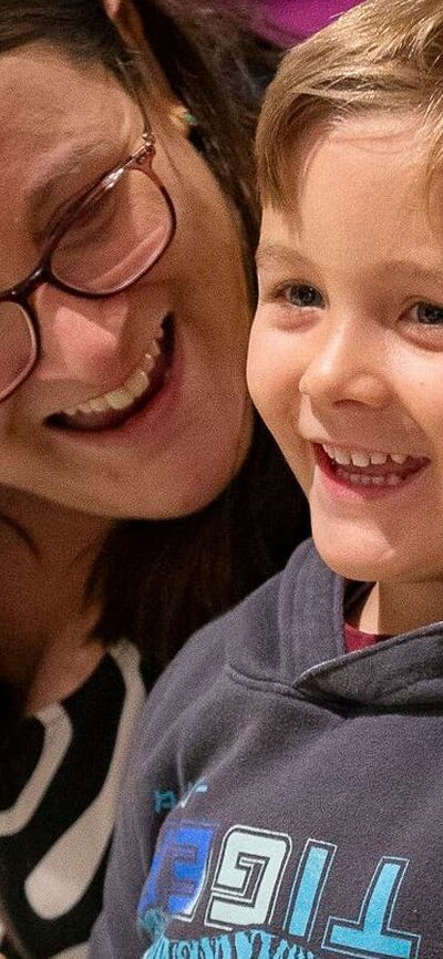 A smiling mother and son enjoying an activity together