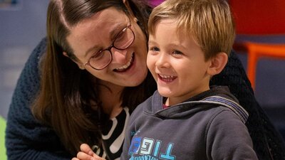 A smiling mother and son enjoying an activity together