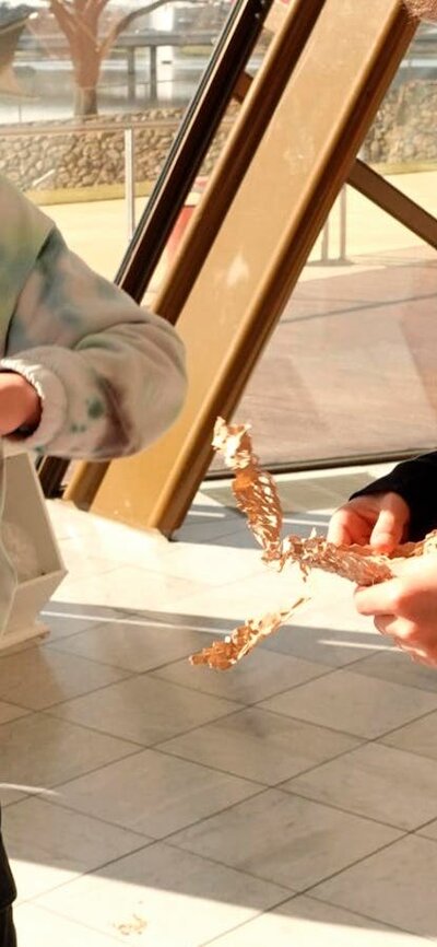 two young boys doing craft with cardboard