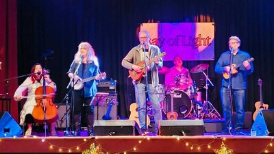 Coolibah Coolective Performing at The Polo Five musicians performing live on stage with cello, banjo, ukulele, acoustic guitar, and drums under