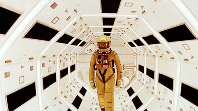 2001: A Space Odyssey (DCP) – Sat 22 Nov, 7:00 PM Man in yellow spacesuit walks towards the camera in sci-fi spaceship surroundings