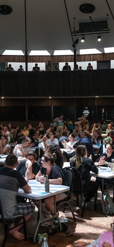 A large room with lots of people sitting at tables