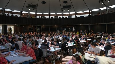 A large room with lots of people sitting at tables