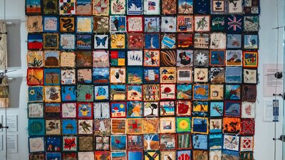 The Immigration Quilt with patches created by different makers to signify connection to country