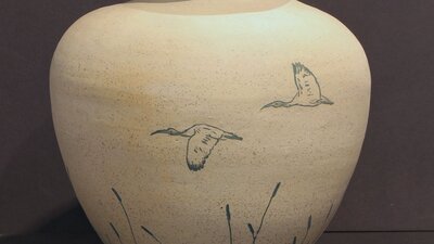 A large ceramic vase painted with birds in flight