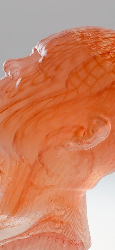 Jeffrey Sarmiento - Encyclopaedia Bust of a head facing upwards. Made from layers of orange glass.