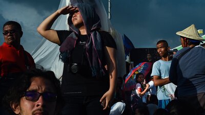 An image of multiple people in a crowd looking around in different directions