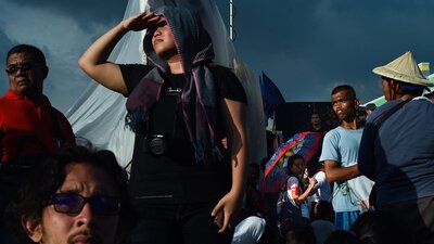 An image of multiple people in a crowd looking around in different directions