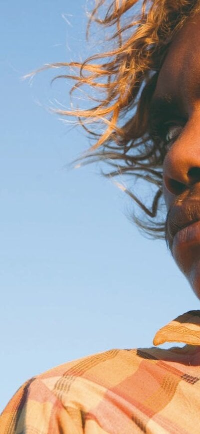 A close up of an adolescent boy looking over his right shoulder