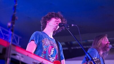 Person ewaring blue t-shirt singing into microphone