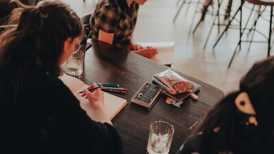 People sitting around a table with pencils and paper