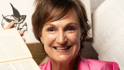 A woman surrounded by books, happy