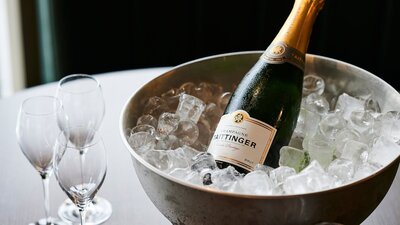 an image of a bottle of champagne in ice with glasses