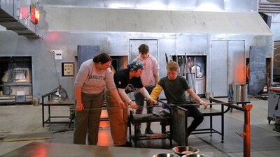 Participants and teacher during glassblowing class