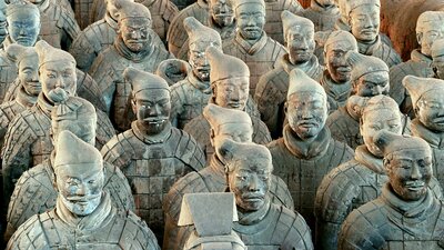 A large formation of terracotta warrior statues in uniform standing in rows.