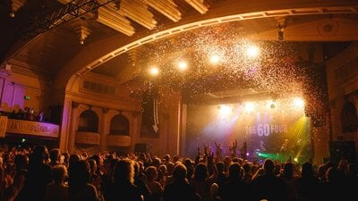 Confetti rains on cheering crowd at The 60 Four concert.