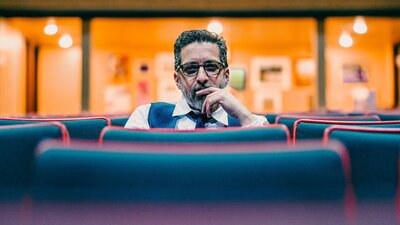 Photo of a man sitting by himself in a theatre