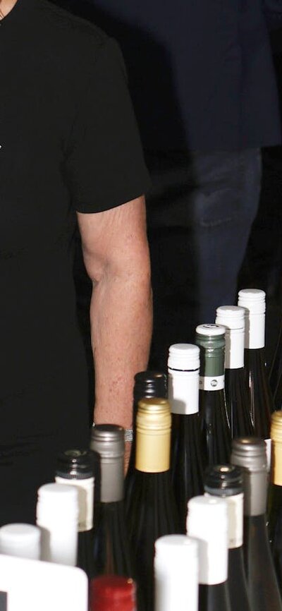 Lady looking at all the bottles of wine for tasting