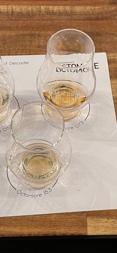 Whisky glasses on placemat filled with whisky alongside event booklet