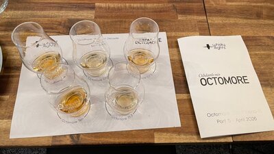 Whisky glasses on placemat filled with whisky alongside event booklet