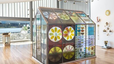 colourful glass greenhouse surrounded by other glass objects and artworks