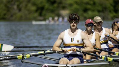 Rowers in a mixed crew sitting in their boat on the lake