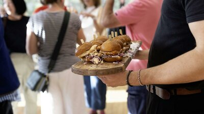 A plate of burgers being served to festival guests