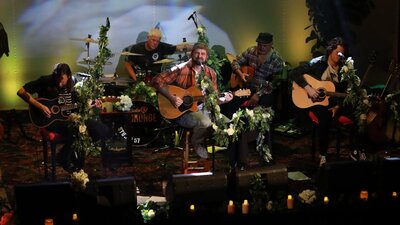 A stage full of musicians with acoustic instruments.
