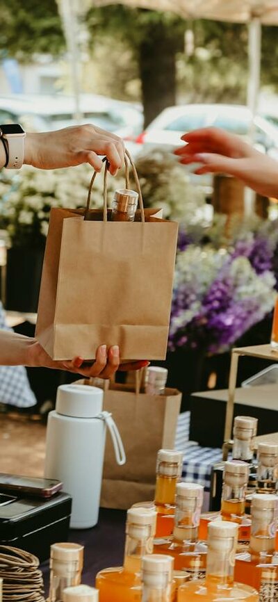 An image of a stallholder handing over a paper bag to a customer