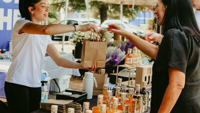 An image of a stallholder handing over a paper bag to a customer