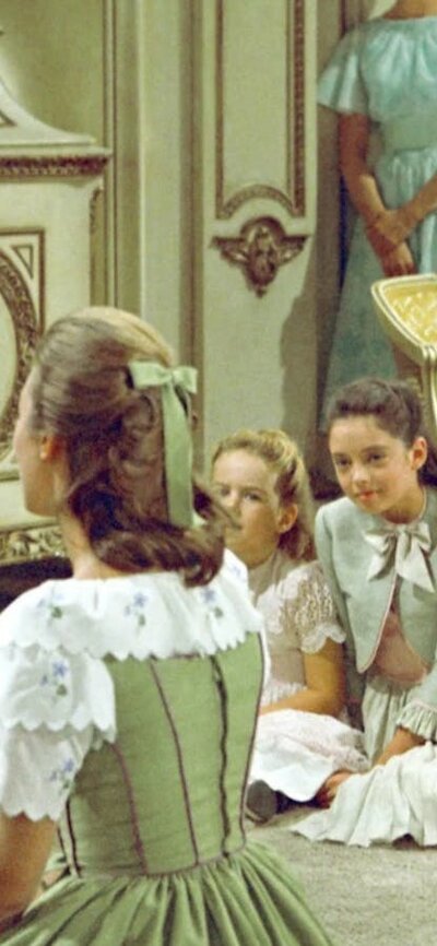 Man sitting in lush interior playing guitar to children sitting on floor