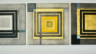 A triptych of abstract printed artworks with motifs of squares.