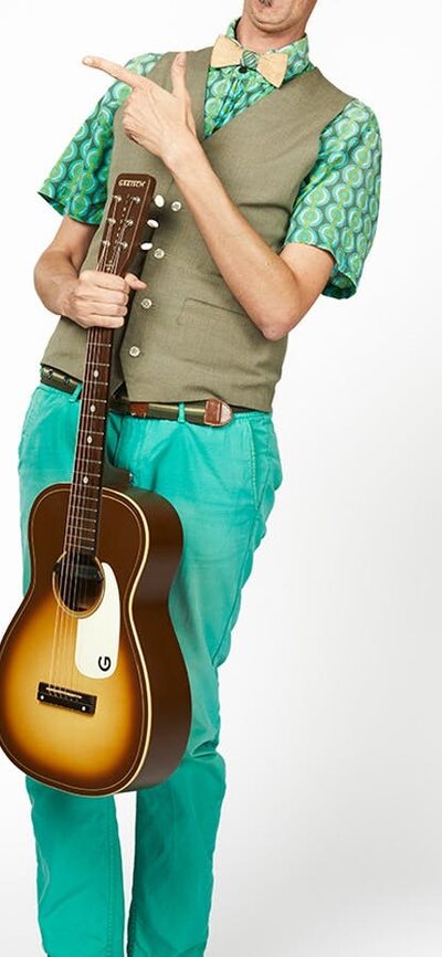 AsparaGus the guitarist wearing blue pants and green hair