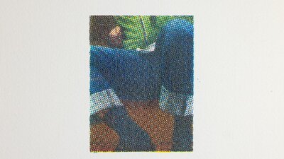 Print of person's legs as they wear deep blue jeans and a bright green top.