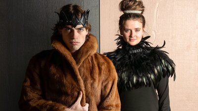 Winter's Tale King and Queen in furs and feathers looking directly at the camera, one happy, one stern