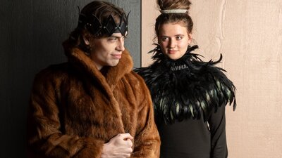 Winter's Tale Queen looking at King, King looking off to the distance, both in furs and feathers