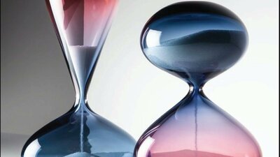 Two hour glasses with sand pouring through them in red and blue glass